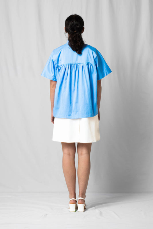 Ciel blue short-sleeve Bowie shirt with button fastening and gathered detailing from the SS26 collection by STEF SERIES shown from the back.