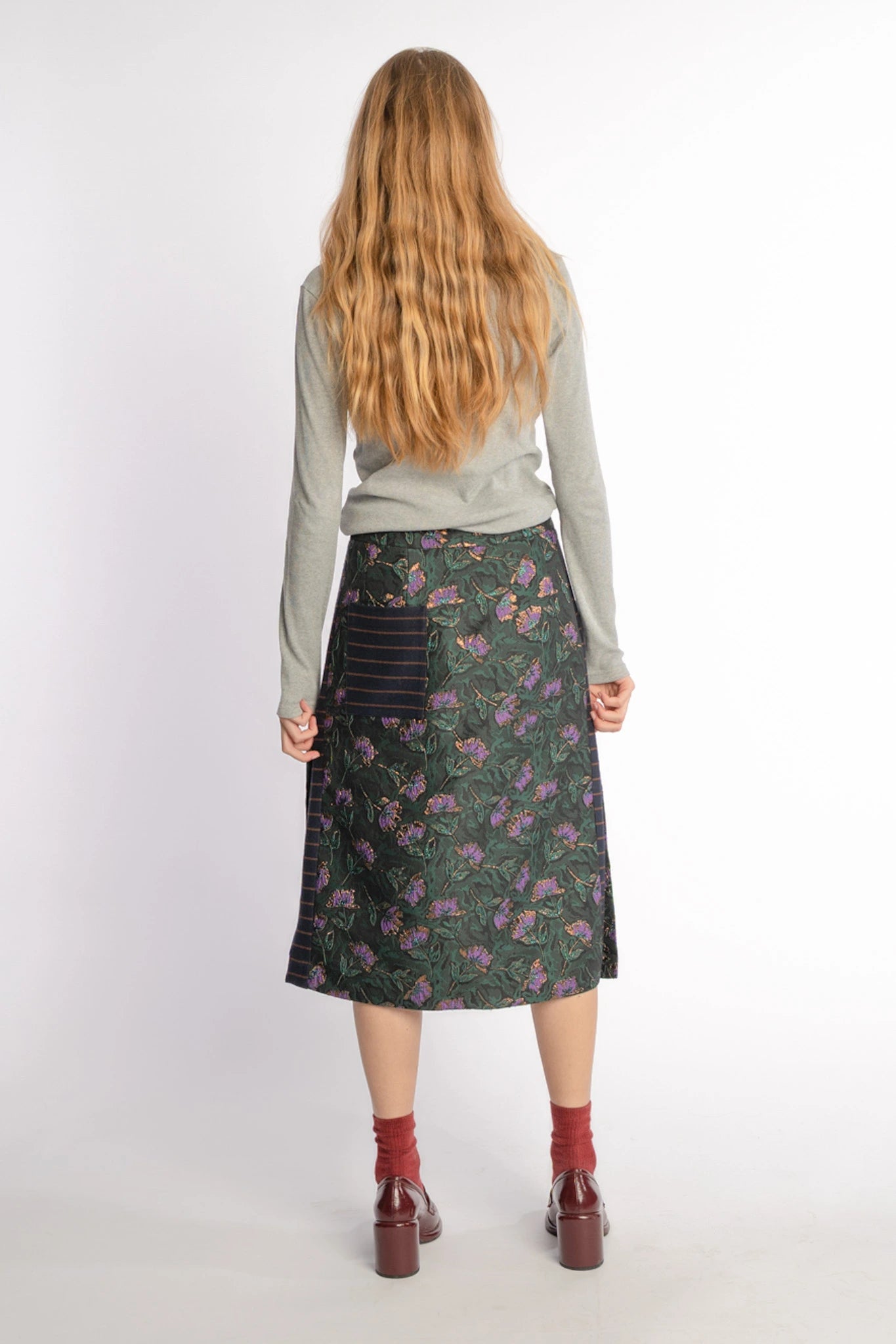 Floral slide-slit skirt Asil in pinegreen and purple from STEF SERIES AW25, shown from back.
