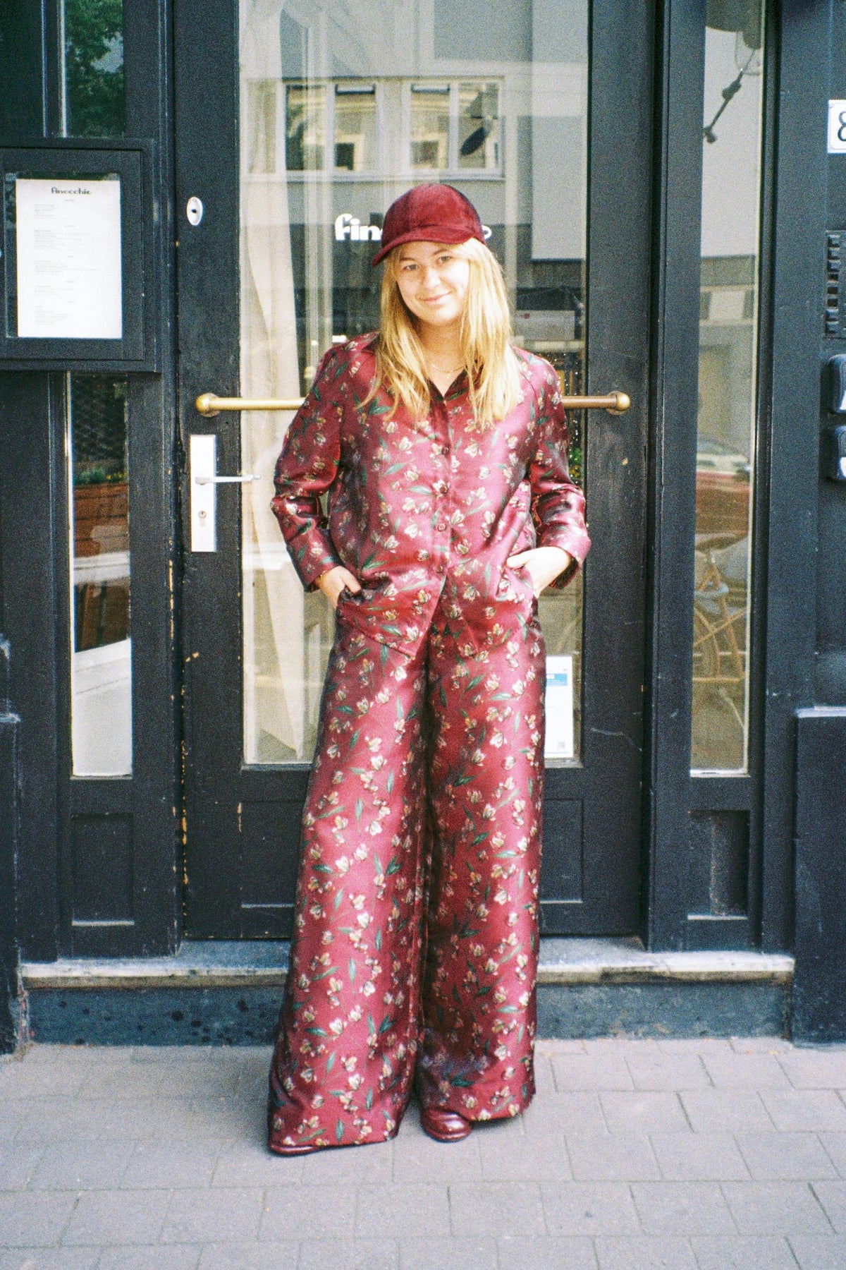 STEF SERIES designer Sam Van Dyck wearing the Coby long-sleeve shirt and Caro wide-leg pants in a red floral print.