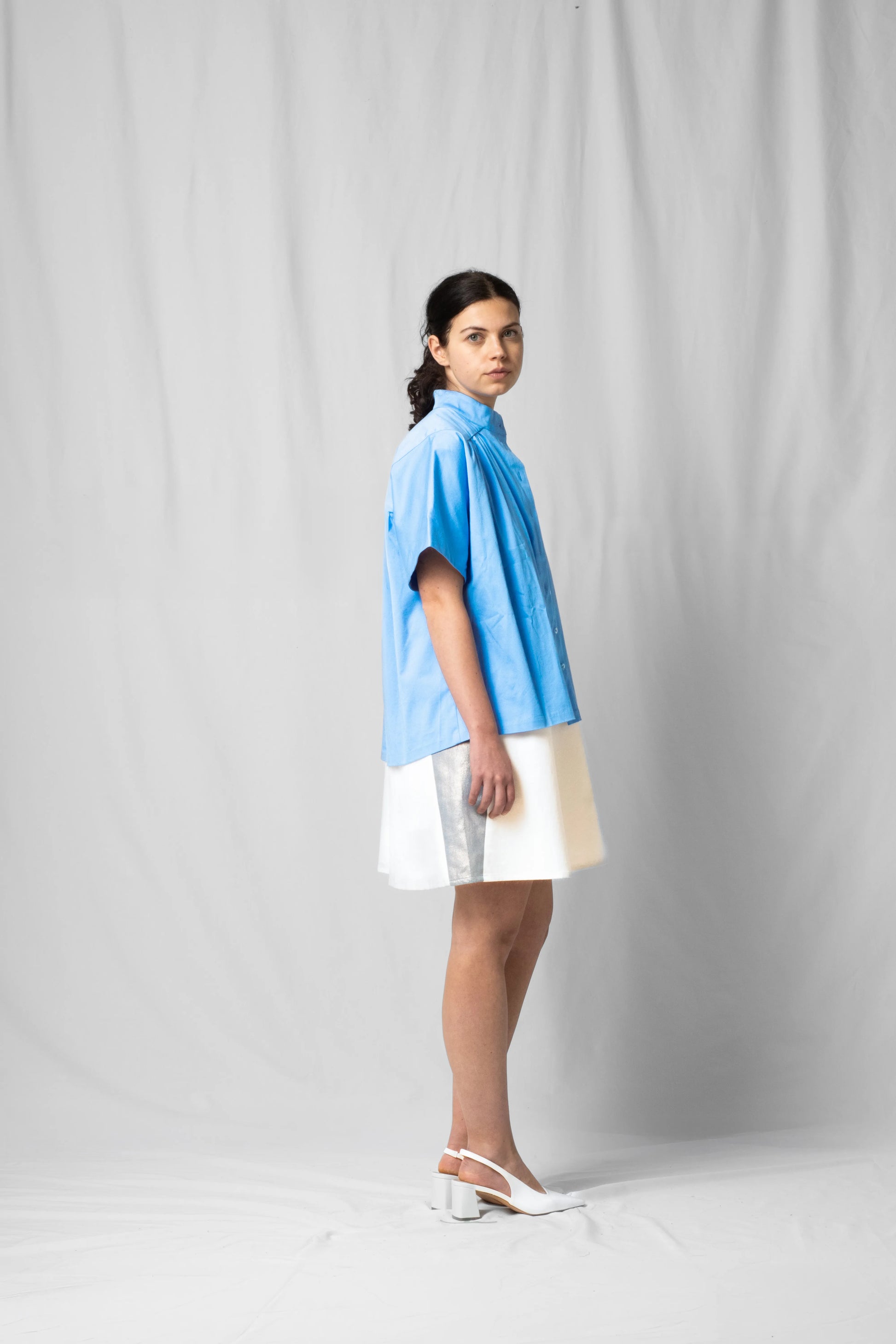 Ciel blue short-sleeve bowie shirt with button fastening and gathered detailing from the SS26 collection by STEF SERIES shown from the side.